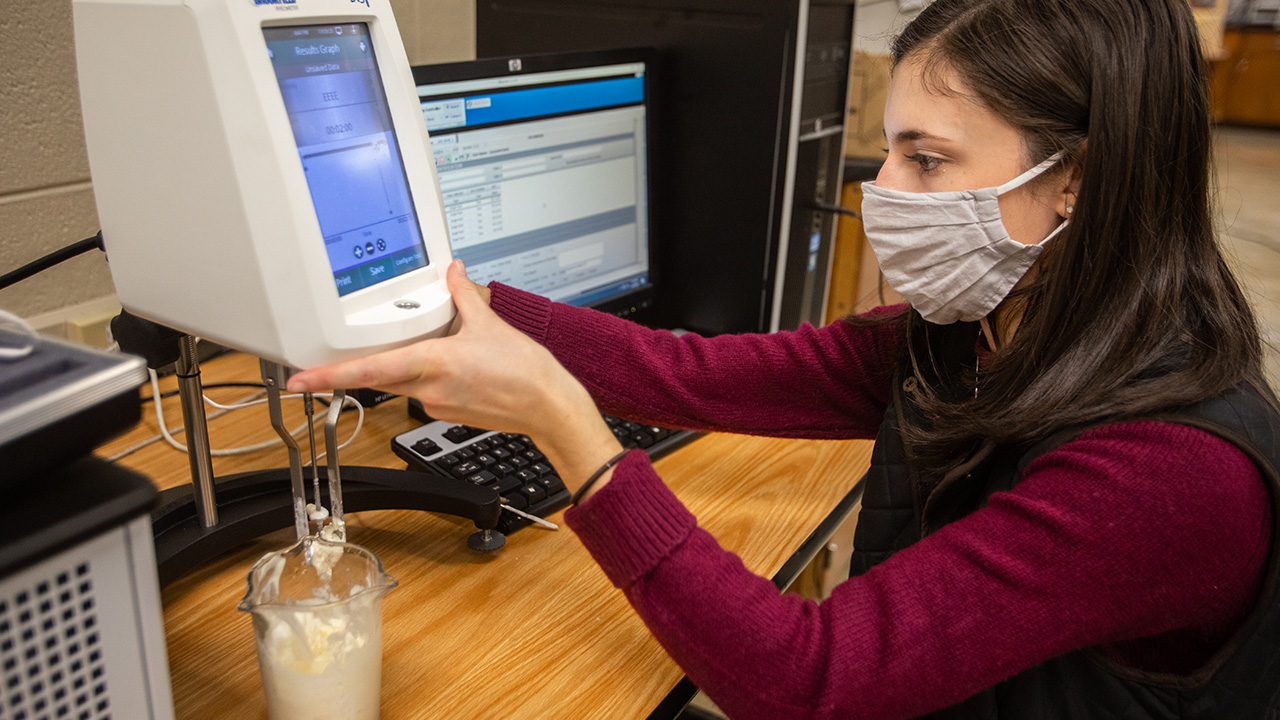 Junior and environmental engineering major Victoria Chanez runs a viscometer test as part of a rheology research project with the Dairy Innovation Hub. 