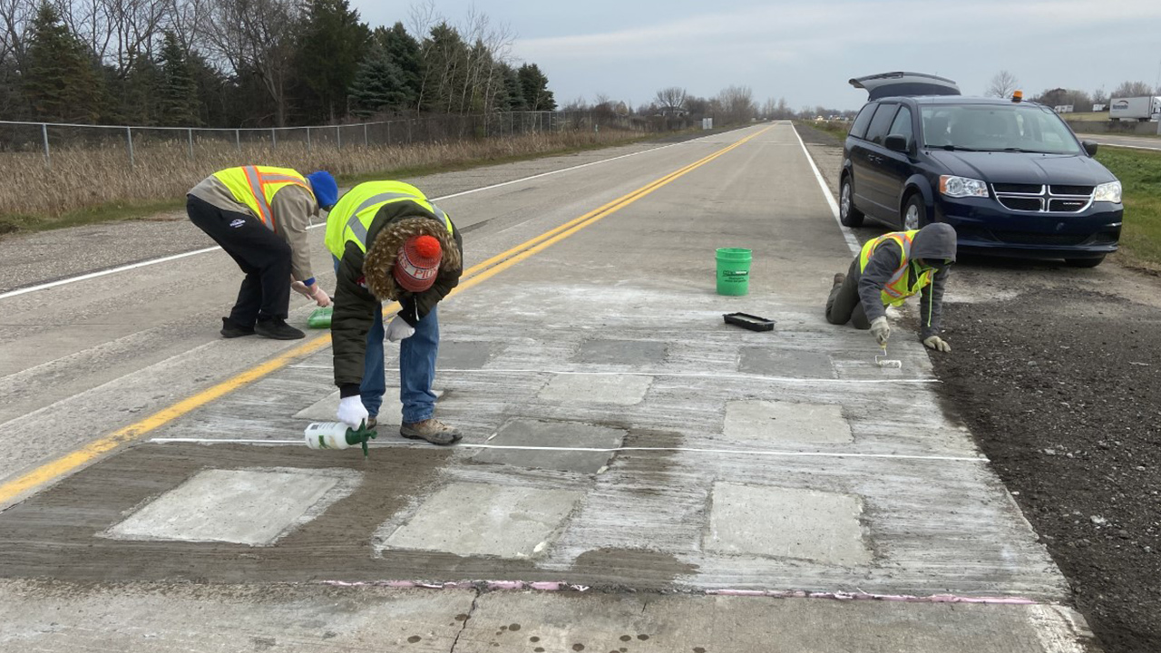 Students apply surface coating on the test track.