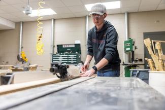 student using the saw in woodworking space