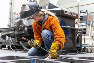 student welding in metalworking space