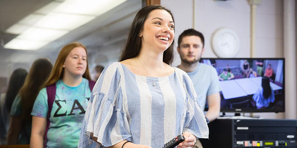 Kornely explains her research project to fellow summer undergraduate scholars program students.