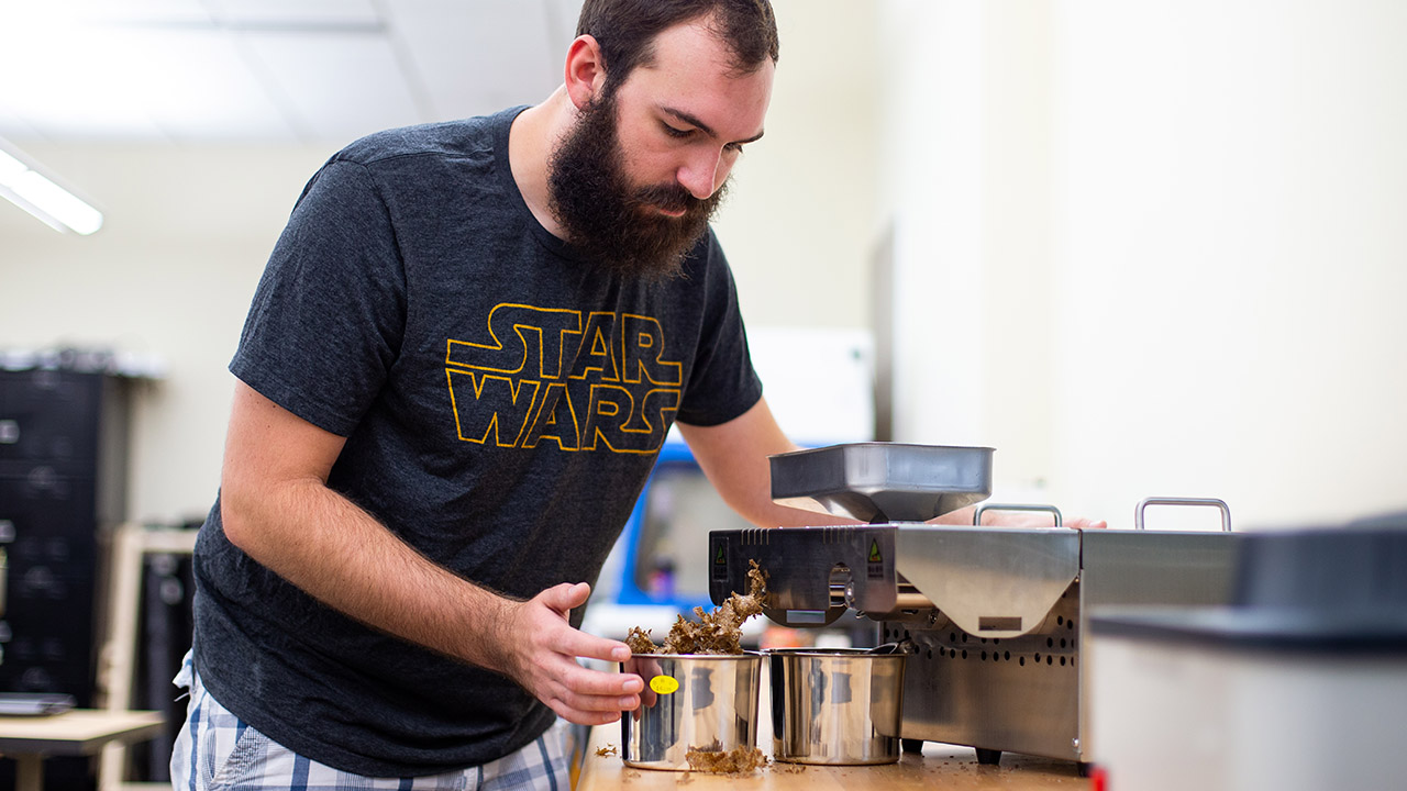 Kyle Ranker, lab assistant for ENRGY:4230 Biofuels class, presses pennycress to extract oil.