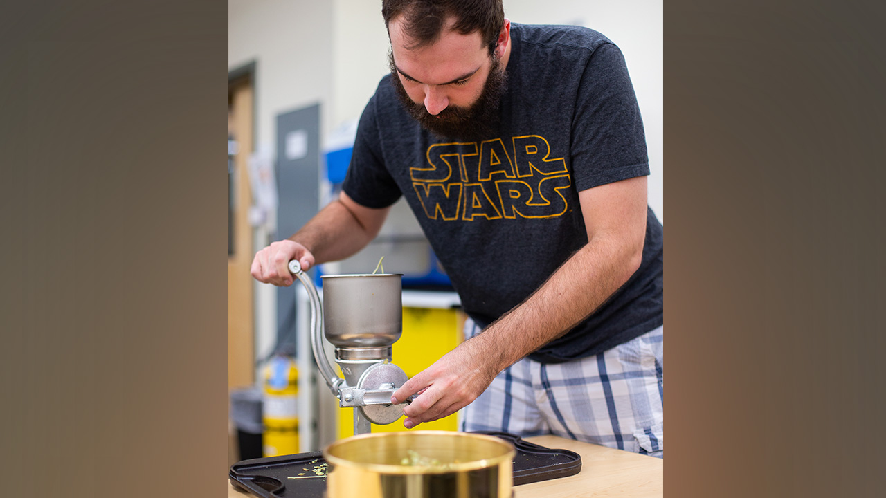 Kyle Ranker, lab assistant for ENRGY:4230 Biofuels class, presses pennycress to extract oil.