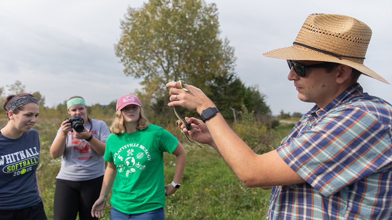 Students researching in field with Dr. John Peterson