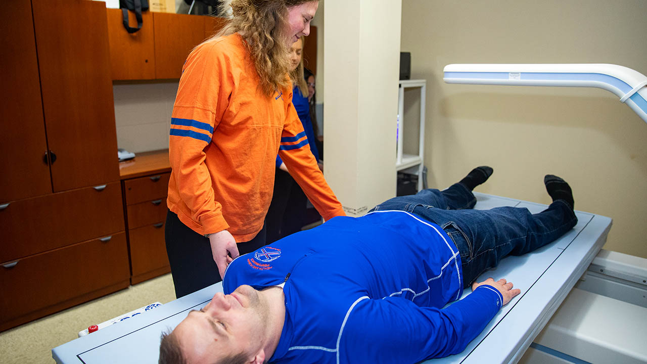 Ann Larson prepares a subject for a DEXA scan.