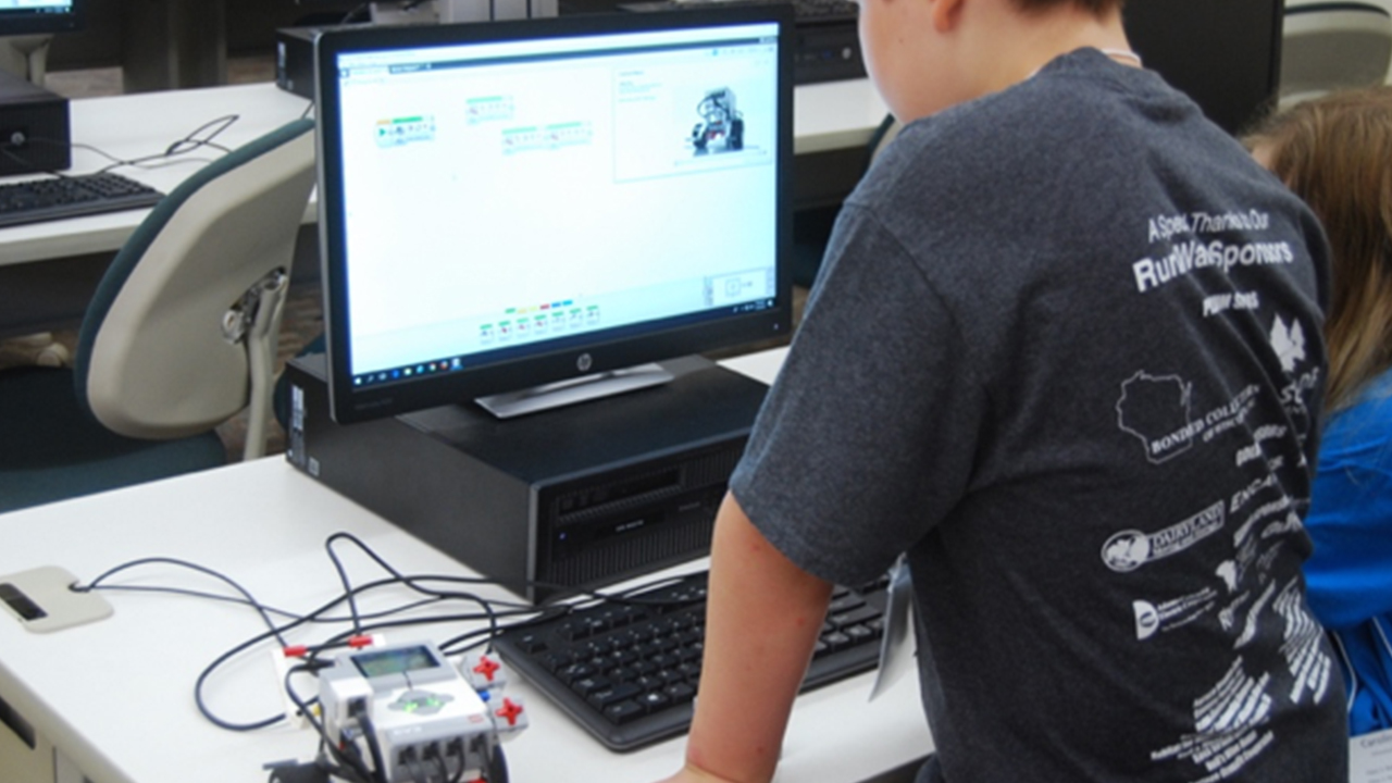 A past participant from College for Kids and Middle School University works on a computer robotics project.