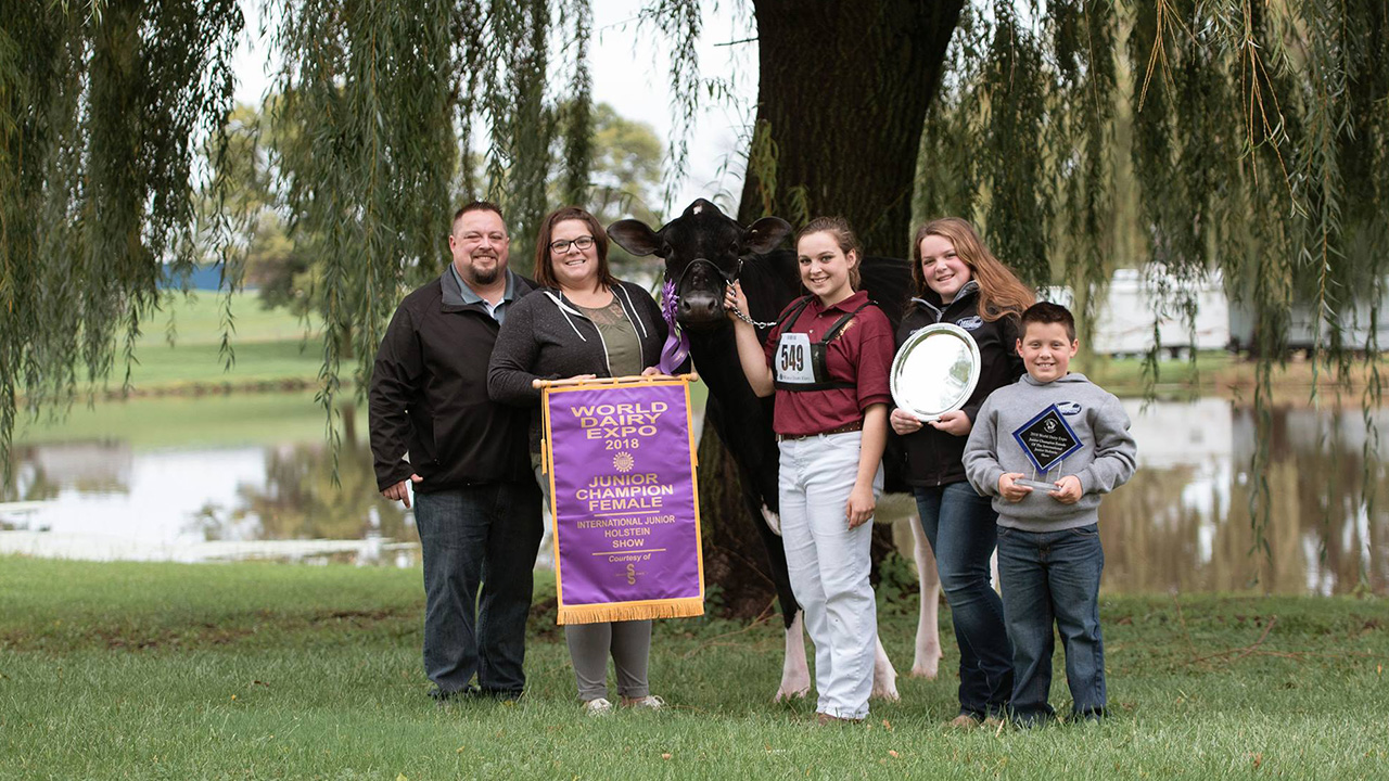 Ryan Weigel and his family with their prize winning cow, Altitude, which Weigel and partners purchased at the Pioneer Dairy Club Classic in 2000. 