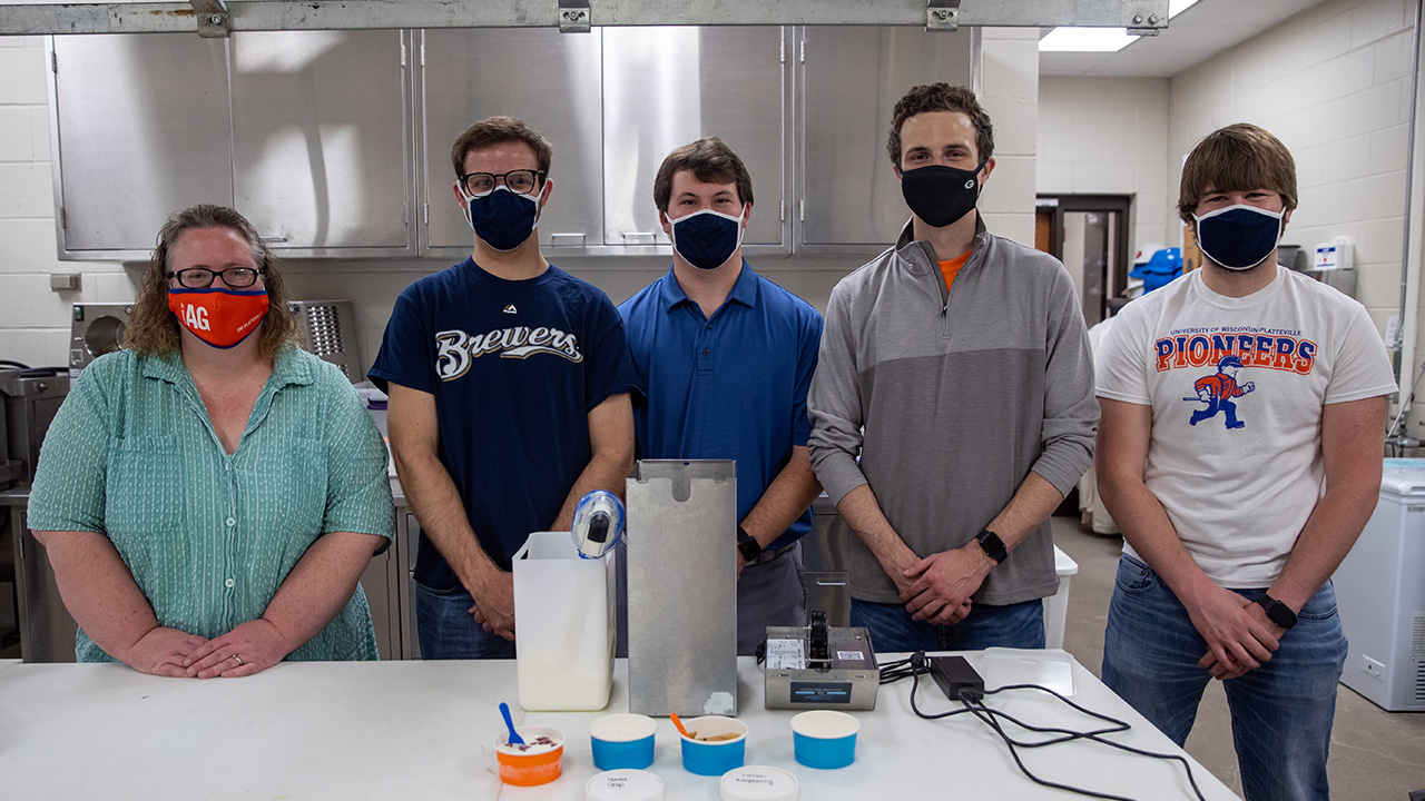 Mechanical engineering student group works on ice cream dispenser.