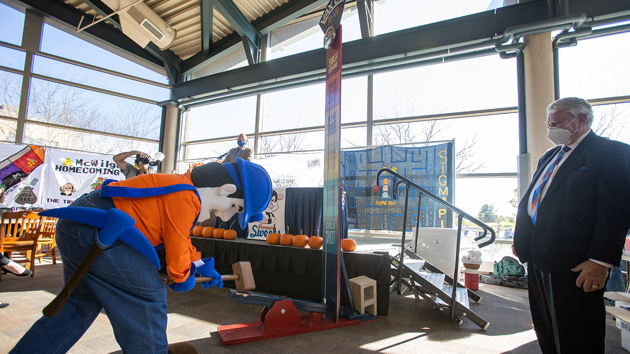 UW System President Tommy Thompson visits UW-Platteville, Pioneer Pete strikes the high bell striker