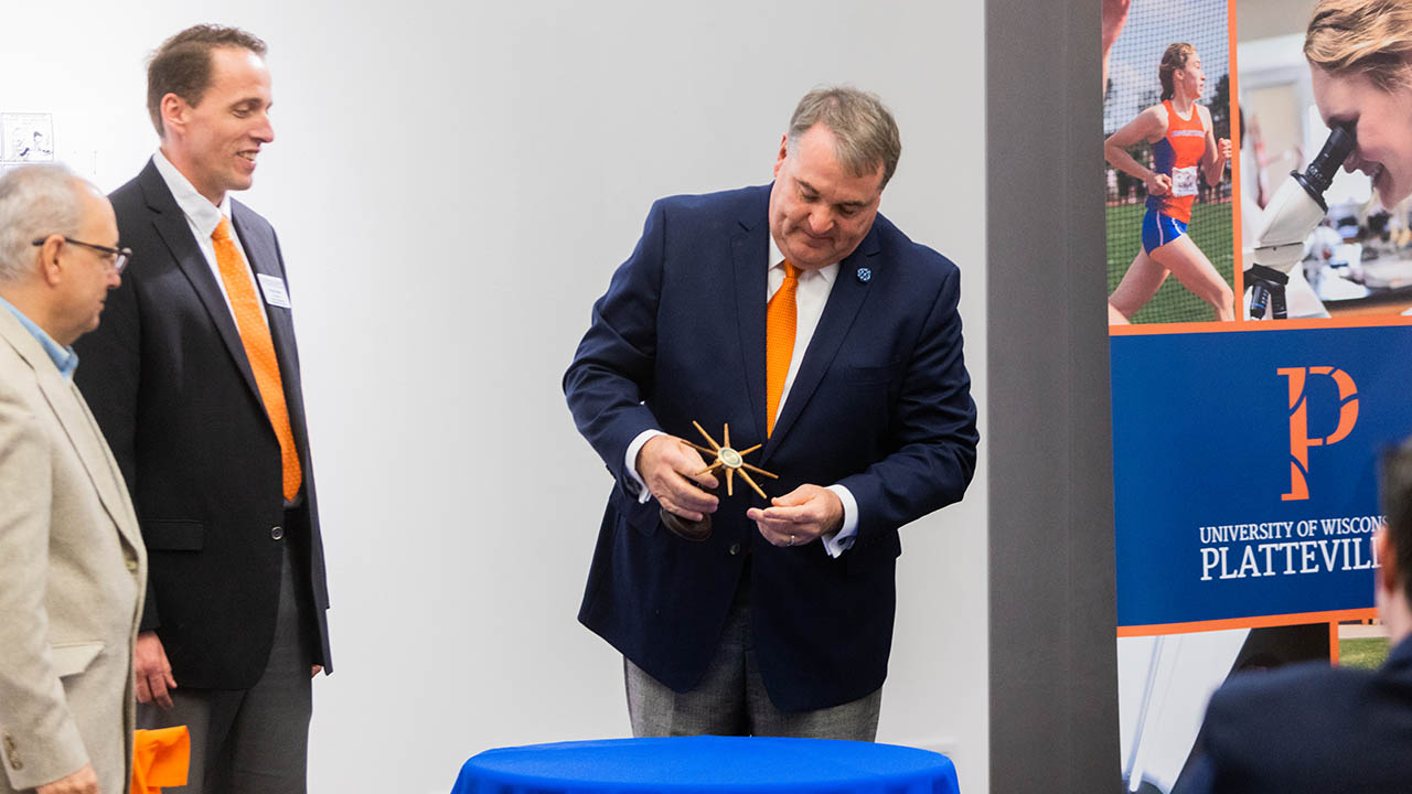 Interim Dean Philip Parker and Tom Cabezas present Todd Johnson with a model capstan made by Cabezas.