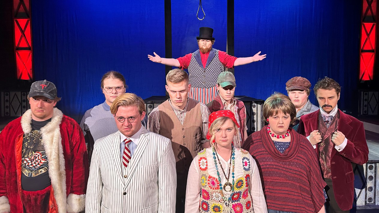 Pictured from left to right in front row: Alex Bartel as Byck, Jamie Wodack as Guiteau, Isabelle Sander as Fromme, Grace Silvestri as Moore and Dylan Schattschneider as Booth. Pictured from left to right in middle row: Rawley Schulz as Hinckley, Charles Soper as Zangara, Max Konop as Oswald and Elijah Fuchs as Czolgosz. Pictured in back row: Daniel Sniff as The Proprietor.