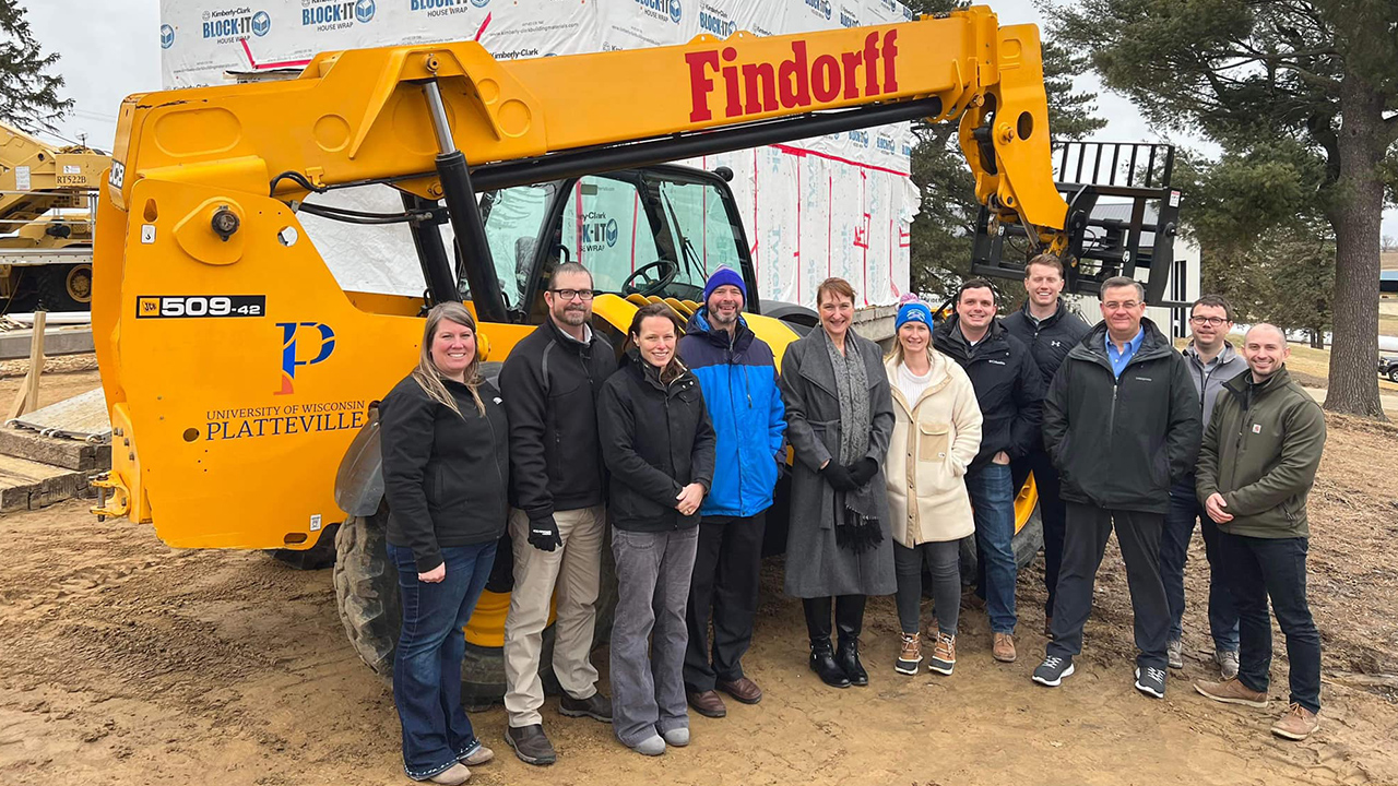 UW-Platteville and Findorff representative stand in front of donated telehandler.