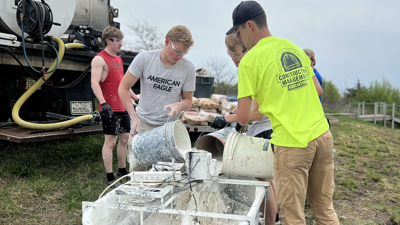 Members of the UW-Platteville chapter of the Society of Automotive Engineers volunteer their time whitewashing the "M."