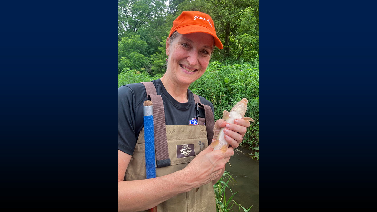 Chancellor Dr. Tammy Evetovich holds a fish as part of the sampling.