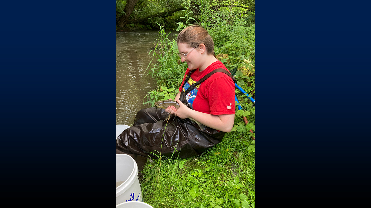 Sophomore Kai Cutler examines a fish as part of the survey process.