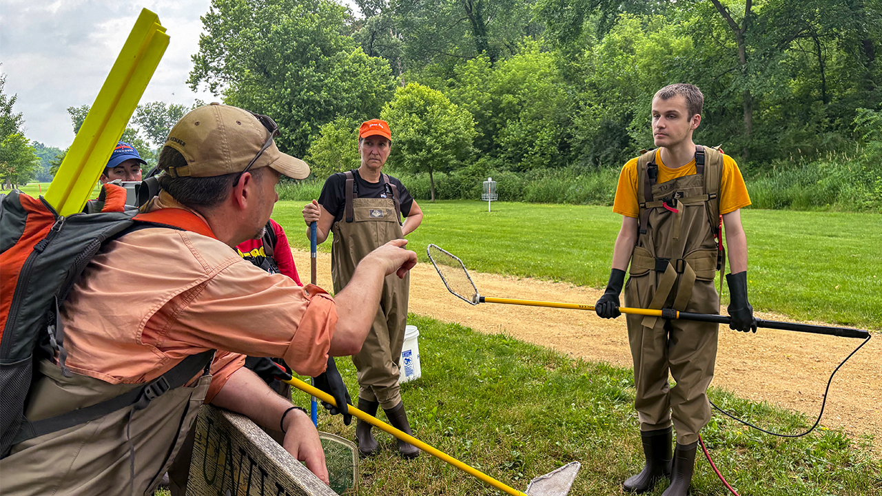 Dr. Kristopher Wright coaches student Noah Braun how to use the equipment.