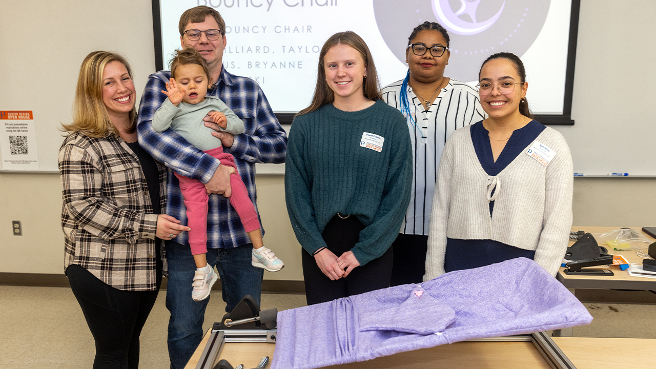 Rachel, Matt and Emma Gunderson with Bryanne Pinkowski, JJ Hilliard, Taylor Nisius and the Gentle Jumps chair in Busby Hall of Engineering.