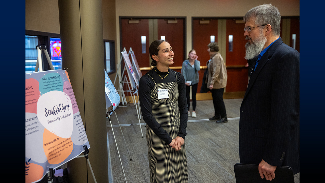Elementary education student Leah Digmann presents her poster to School of Education Director Dr. Tim Buttles.