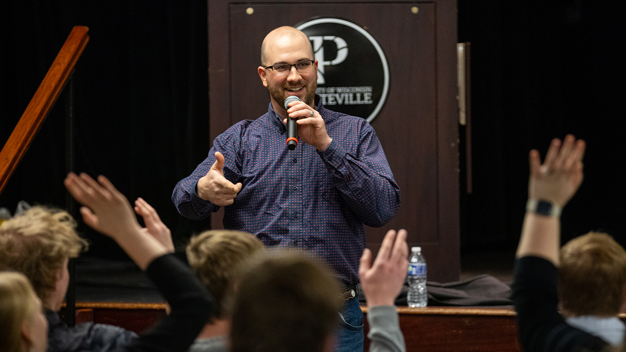 Keynote speaker and alumnus Justin Doyle highlights the importance of teacher enthusiasm, reminding the audience that educators must bring energy to the classroom.