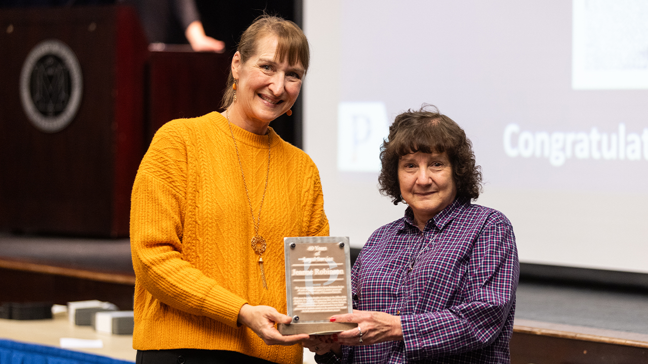 Chancellor Tammy Evetovich presents an award to Robinson on November 21, 2024, in recognition of 40 years of dedicated service to UW-Platteville.