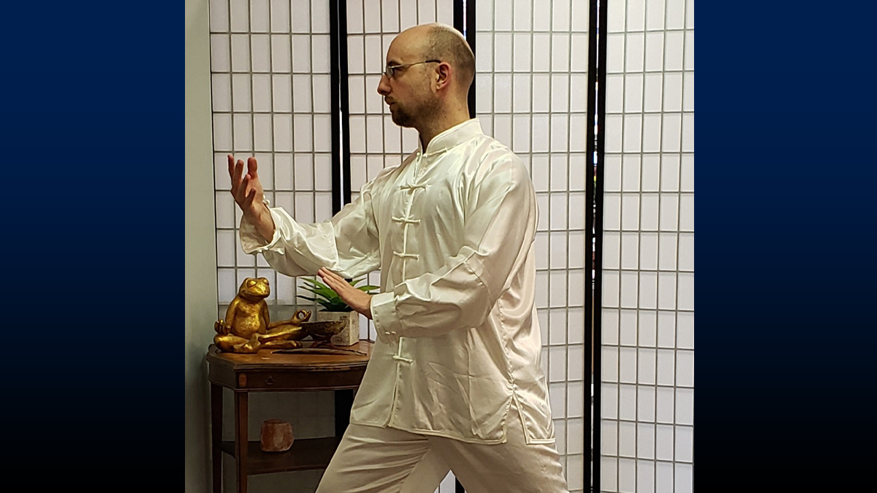 Pitcher demonstrating the tai chi movement "Parting the Wild Horse’s Mane" with focus and grace.