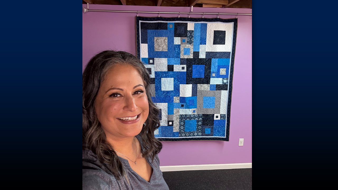 Sifri with a quilt she started last year and finished after taking a free motion quilting class in January.