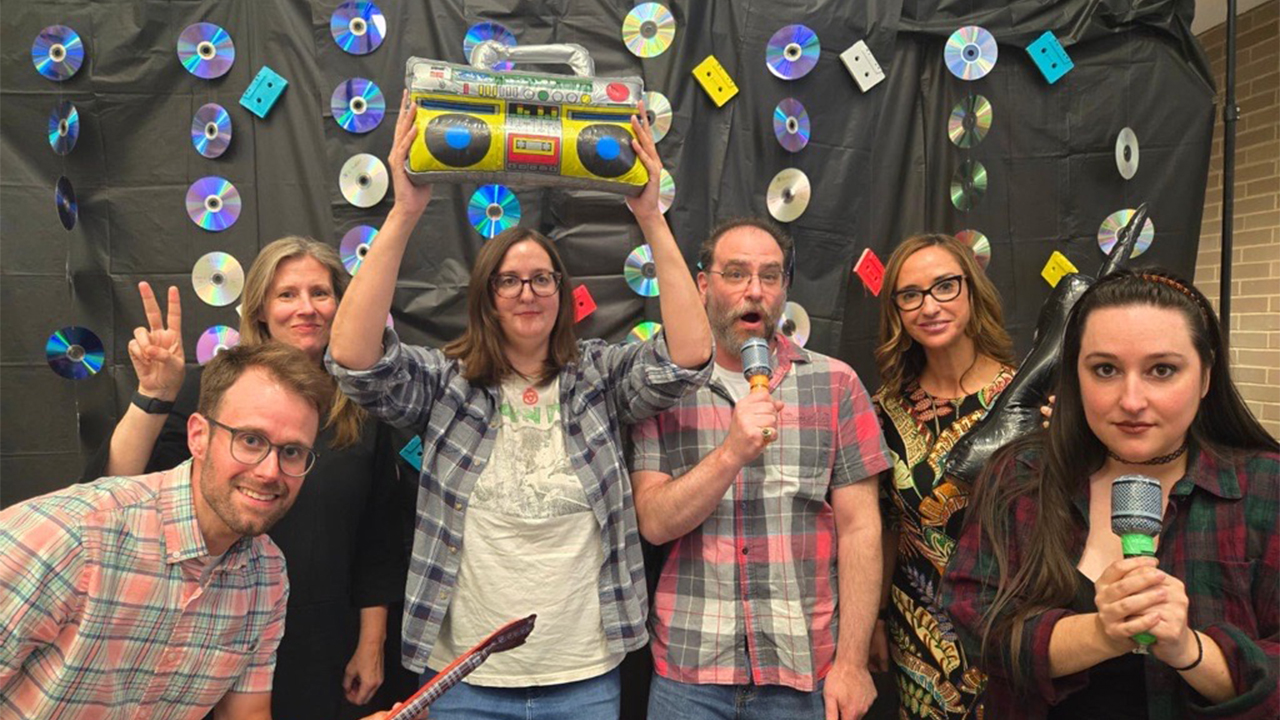 Humanities Department colleagues celebrating the 2025 Spirit Kale Review Launch Party (’90s theme!). Clockwise from left: Michael Lambert, Dr. Katie Kalish, Dr. Amanda Tucker, Dr. David Gillota, Kara Candito and Dr. Hannah Korell.