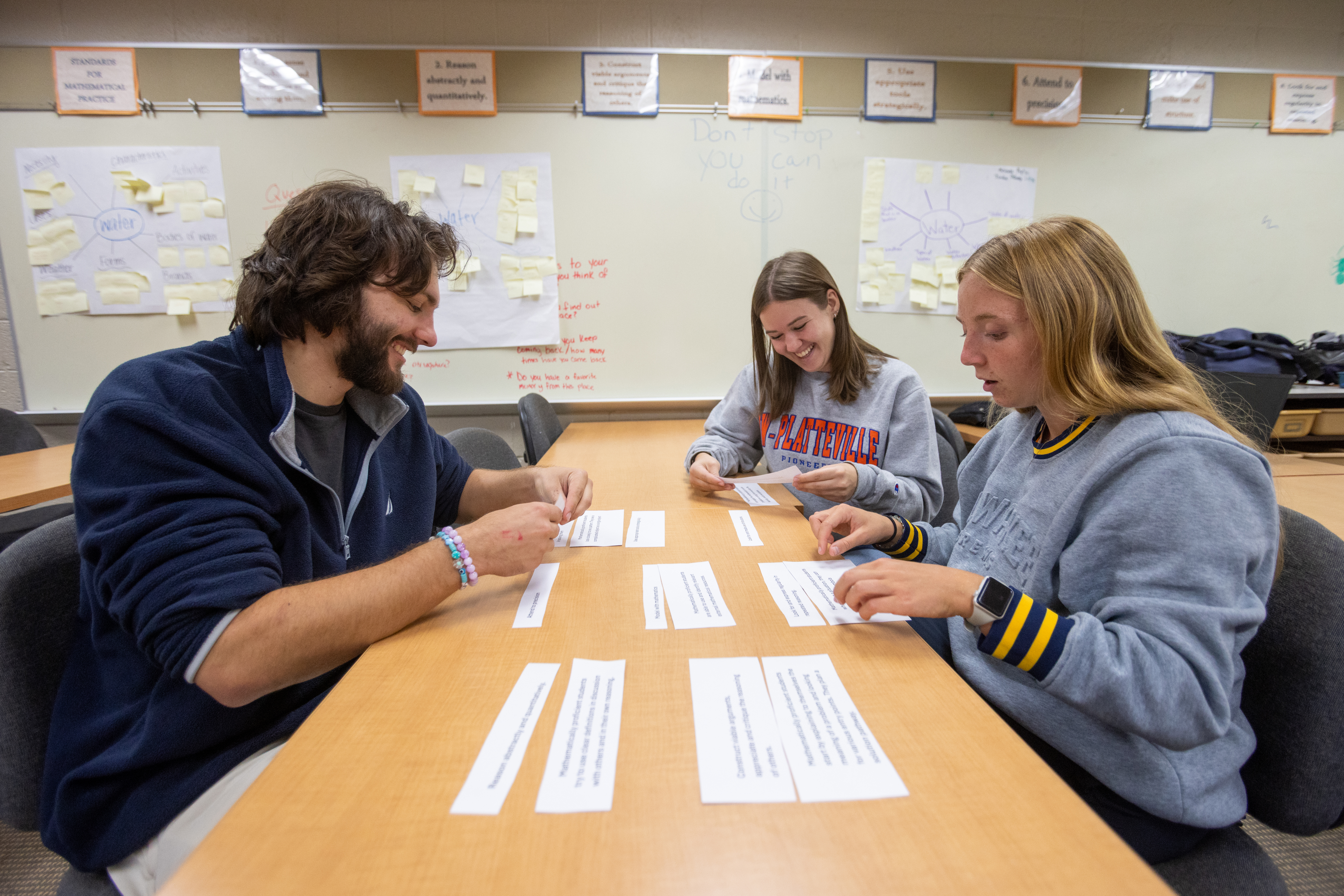 Three students working through an activity at a table