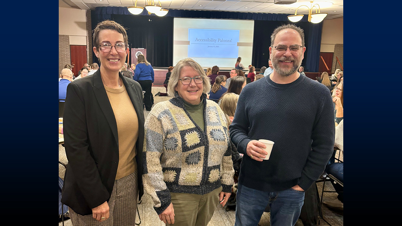 Three people posing for a picture in the meeting room. 