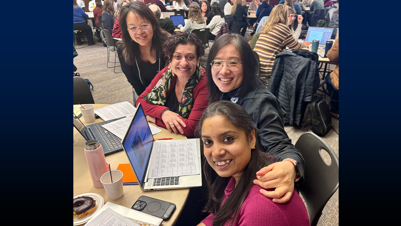 Group of women at a table smiling. 