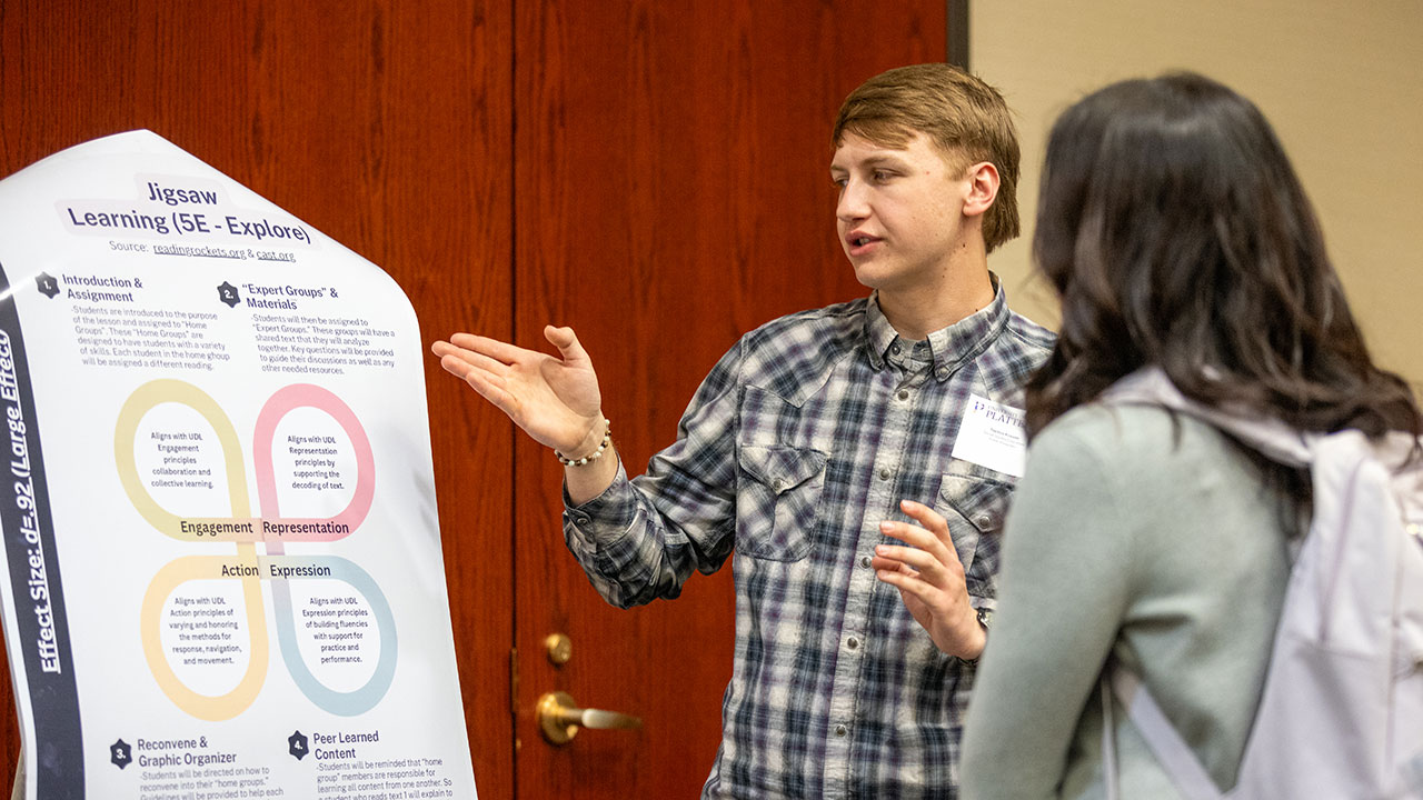 A UW-Platteville student references his project during the poster session.
