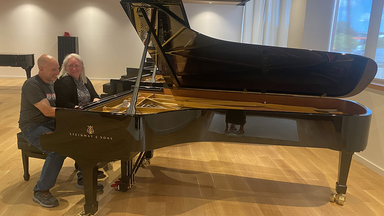 Man and woman sitting at Steinway grand piano