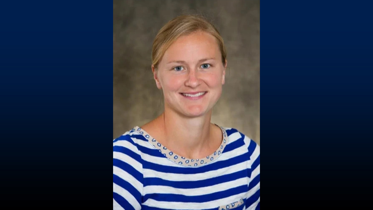 Headshot of smiling woman with blonde hear, wearing a blue and white striped sweater