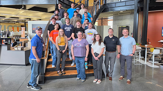 Group of students and faculty standing on a staircase