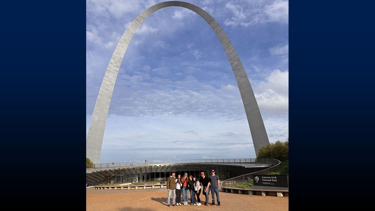 Group of students standing under the St. Louis arch