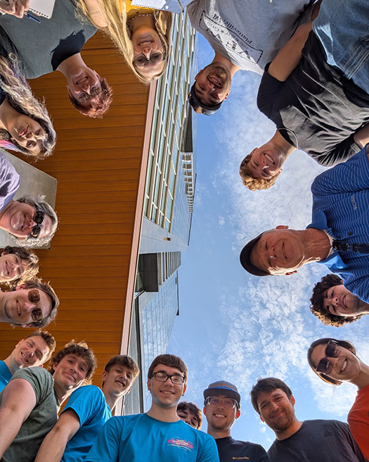 Selfie of students and faculty standing in a circle