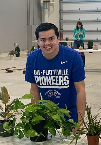 UW-Platteville's Luis Avila Vette poses with plants on a table at the 2026 North American Colleges and Teachers of Agriculture Annual Judging Conference at Illinois State University in April.