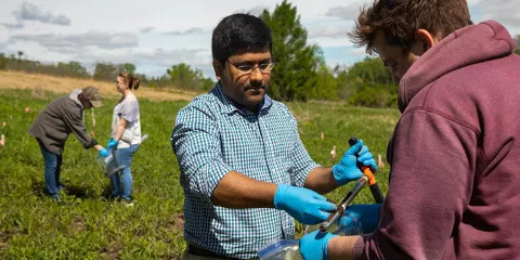 Dr. Muthu Venkateshwaran and his student researchers collect soil samples for prairie soil microbiome project.