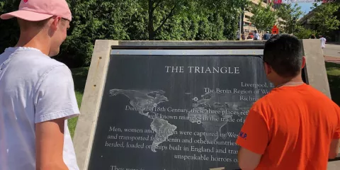 Brandon Larsen and Parker Debroux look at a map of the commemorative plaque acknowledging the slave trade triangle that allowed Richmond to be one of the wealthiest cities in the South.