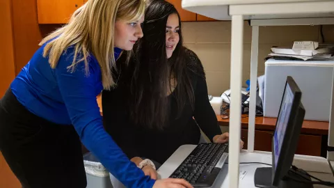Brooke Kunkel and Monica Radtke examine the results of a DEXA scan.