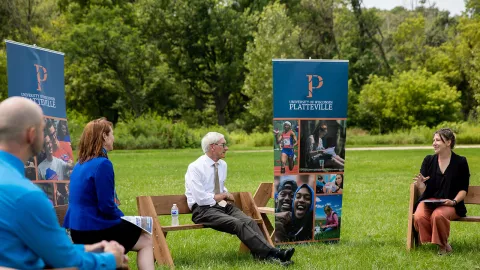Gov. Evers meets with university leadership in Memorial Park, site of solar array