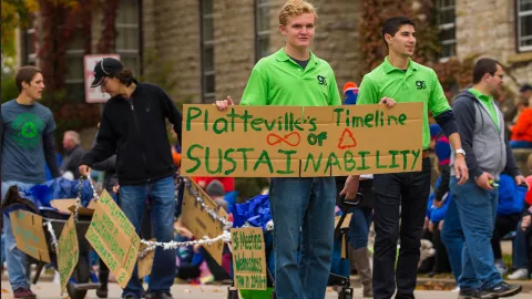 Students in parade holding sustainability sign