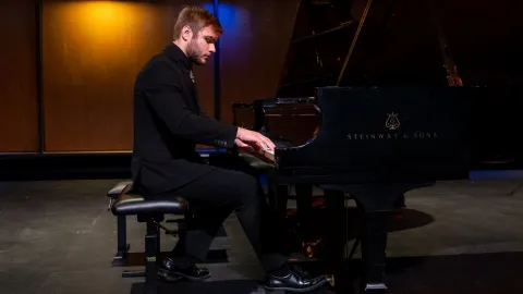 Ethan Squires rehearses his piano piece before a recital in Brodbeck Concert Hall.