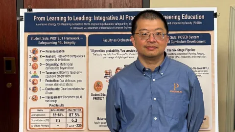 Man in blue shirt standing in front of research poster.