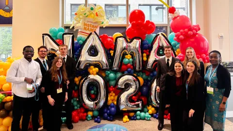 Group of students standing around balloons that read NAMA 2026
