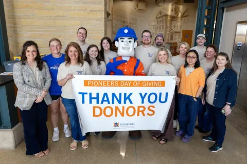 UW-Platteville students hold up a banner thanking donors for their contributions.