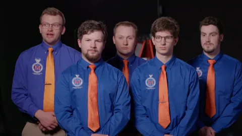 The five members of the 2025 Pour'n Pioneers pose at the Cast in Steel competition in their blue uniform shirts and orange ties.. 