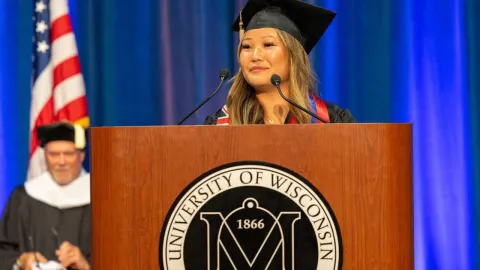 Agiimaa Kerwin speaks from behind a podium during UW-Platteville's College of Business, Industry, Life Science and Agriculture graduation ceremony on May 16, 2026.
