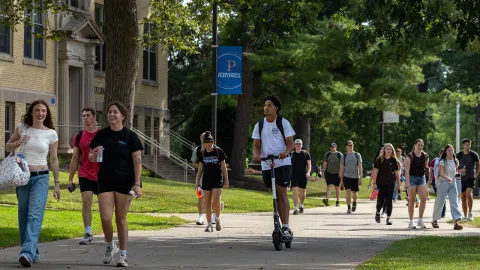 UW-Platteville students move along a campus sidewalk on a sunny morning. 