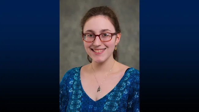 Headshot of smiling woman in blue shirt
